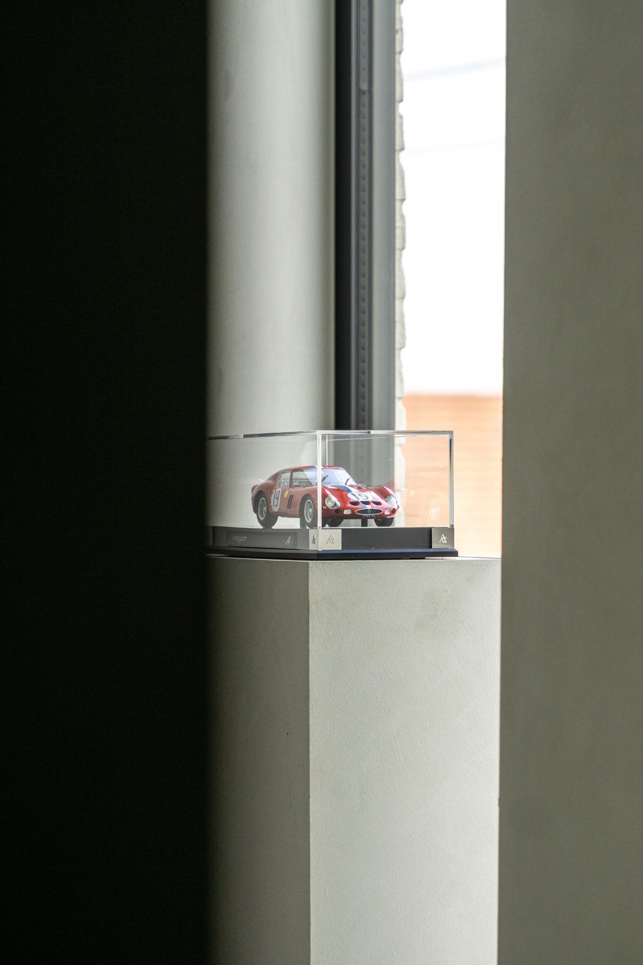 Vitrine met modelauto op sokkel
