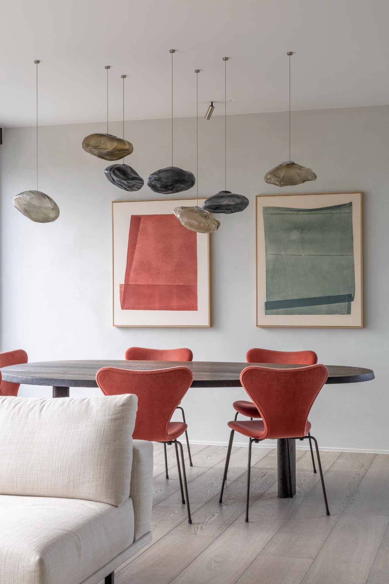 Eetruimte met terracotta stoelen en kunst